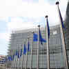 An external photo of the European Union headquarters in Brussels with three EU flags flying at the front