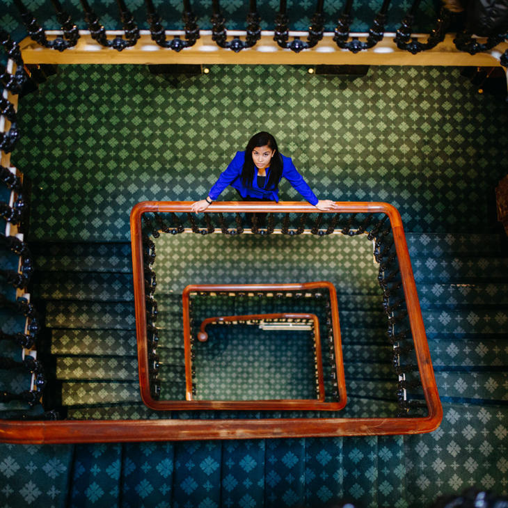 Hull Politics student, Jacqueline Gomes-Neves, stands on a winding staircase in Westminster looking up to the camera.