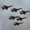 A group of five F16 fighter jets flying through a cloudy sky