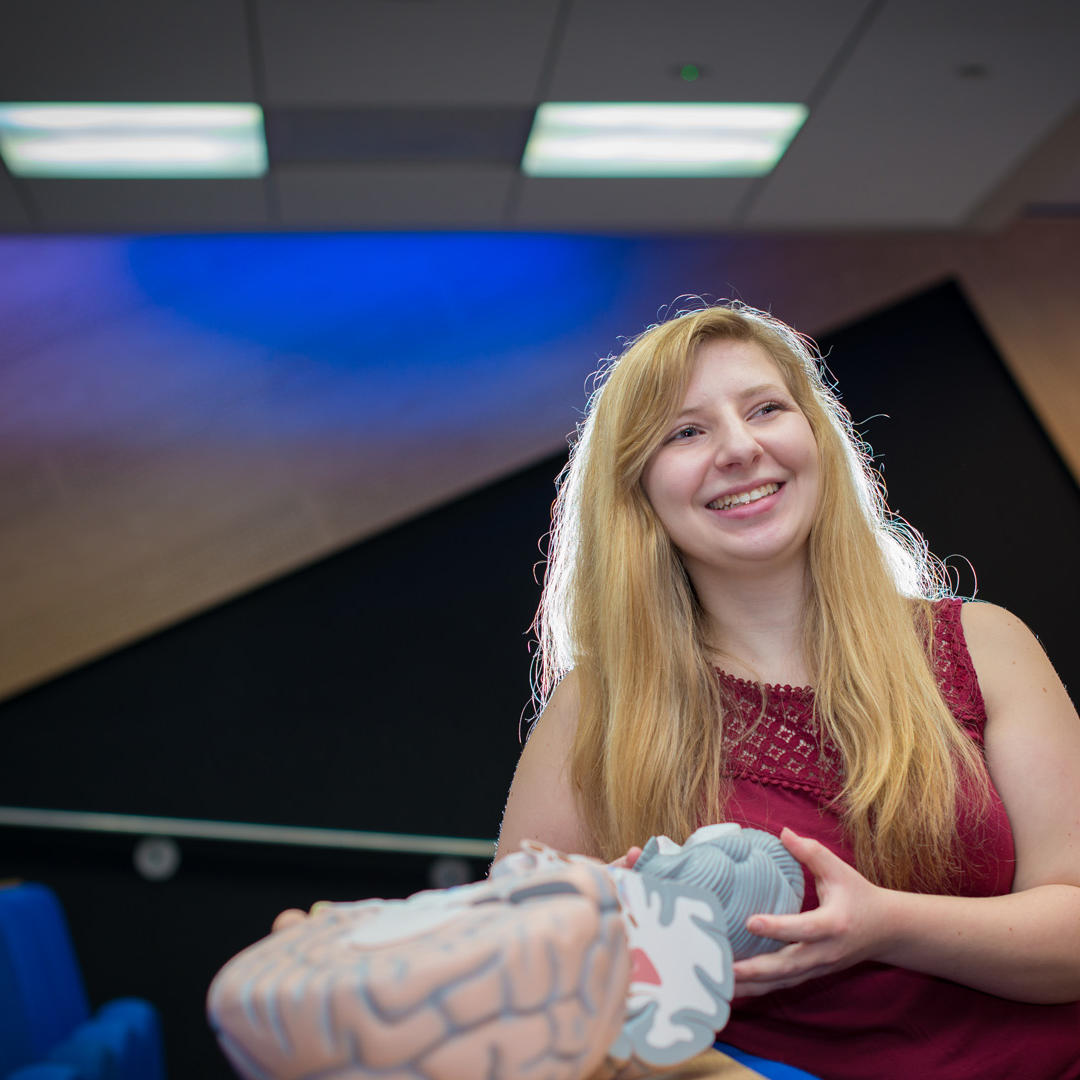 lisa stafford, psychology student, holding a model of a brain