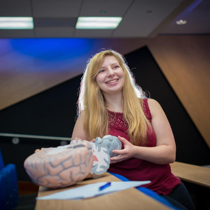 lisa stafford, psychology student, holding a model of a brain