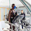 A student wearing an oxygen max runs on a treadmill while being monitored by a member of staff