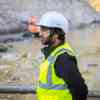 A male worker wearing a hi vis jacket and hard hat