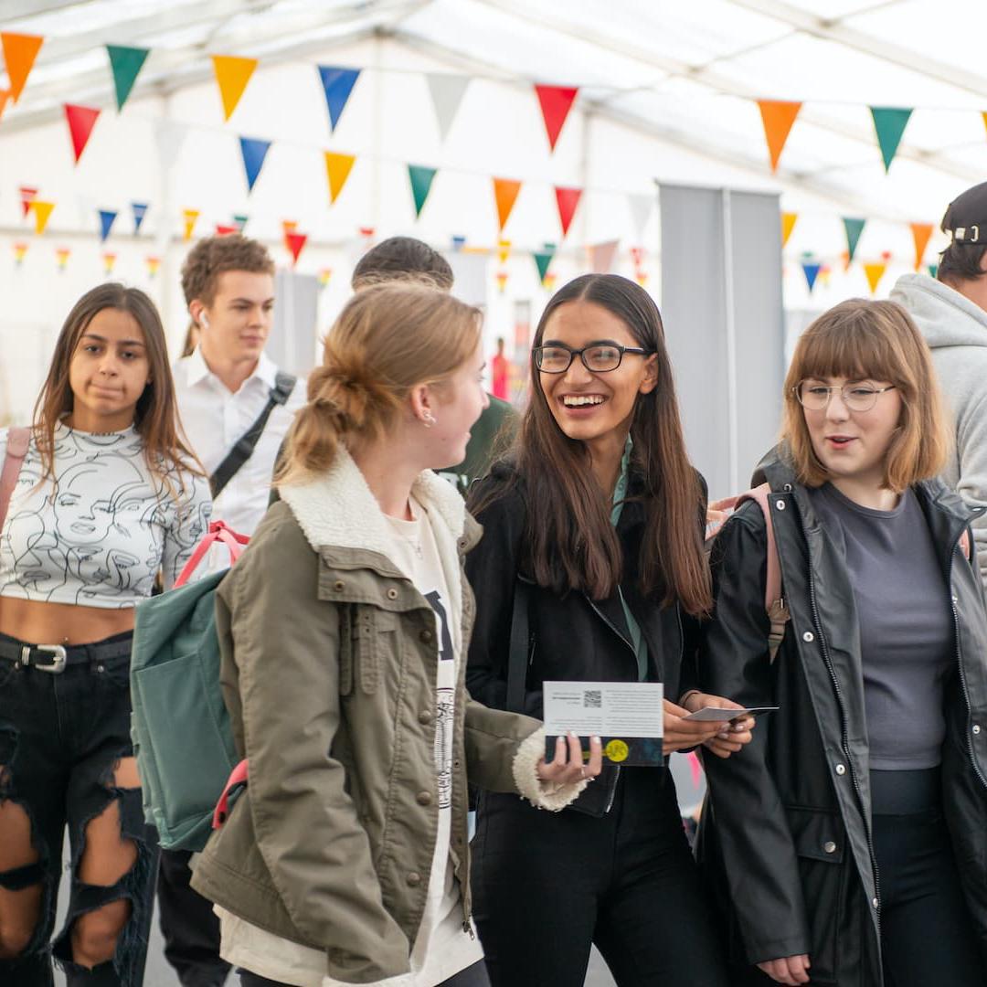 A group of students walking around a societies and volunteering fair on campus