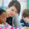 A teacher works closely with young children in the classwoom