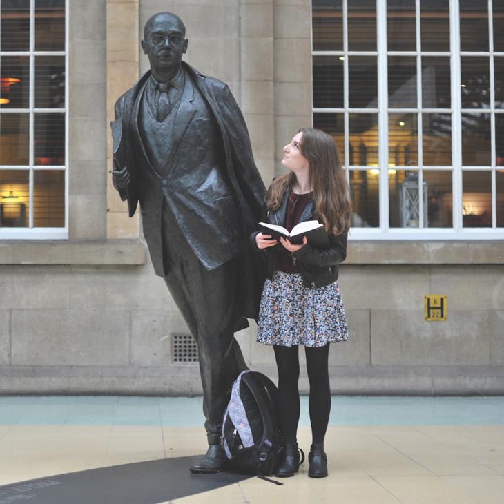 An english student stood with statue of Philip larkin in the city's rail station