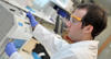 A male scientist wearing protective equipment works in a laboratory 