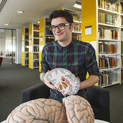 Student in the library with models of brains