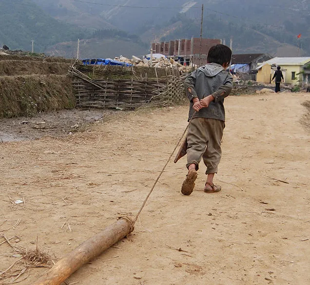A child dragging some wood - child labour