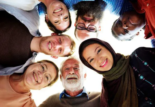 A group of people standing over a camera and smiling