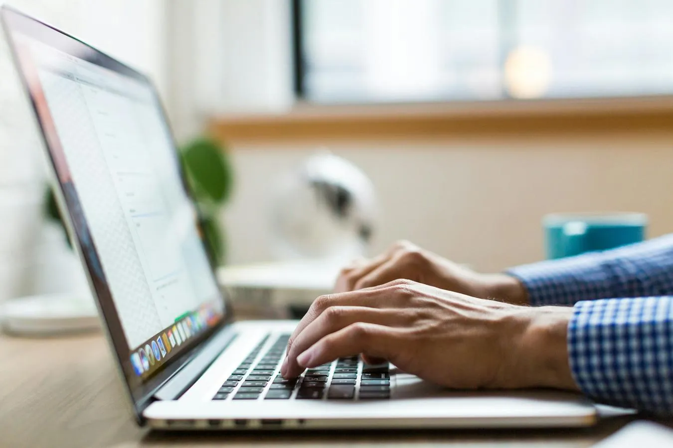 Close up of hands typing into a laptop
