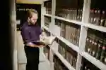 A student reads a book in front of library shelves