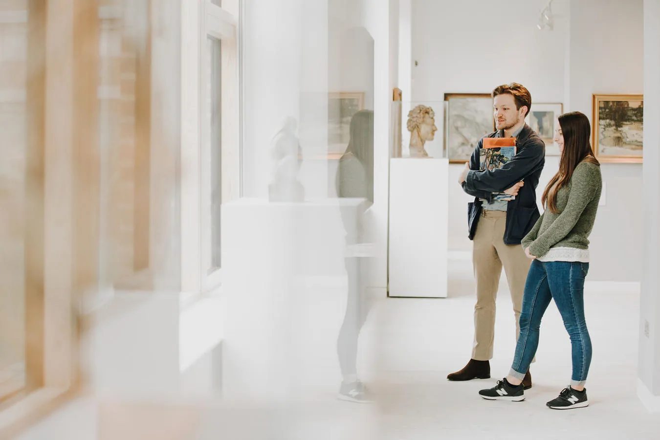 Two students stand in an art gallery