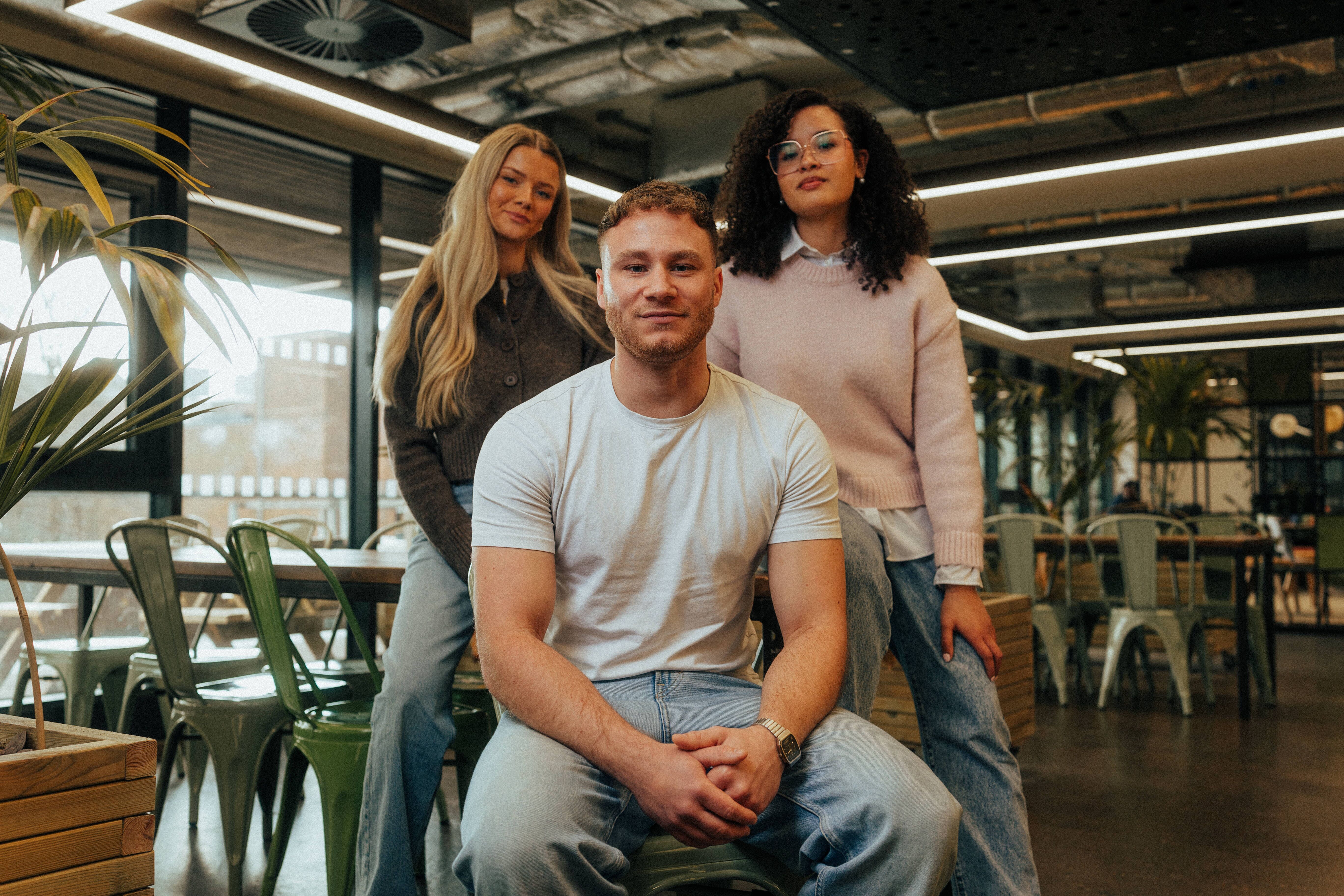 Three students in a group in student social space, the Nest