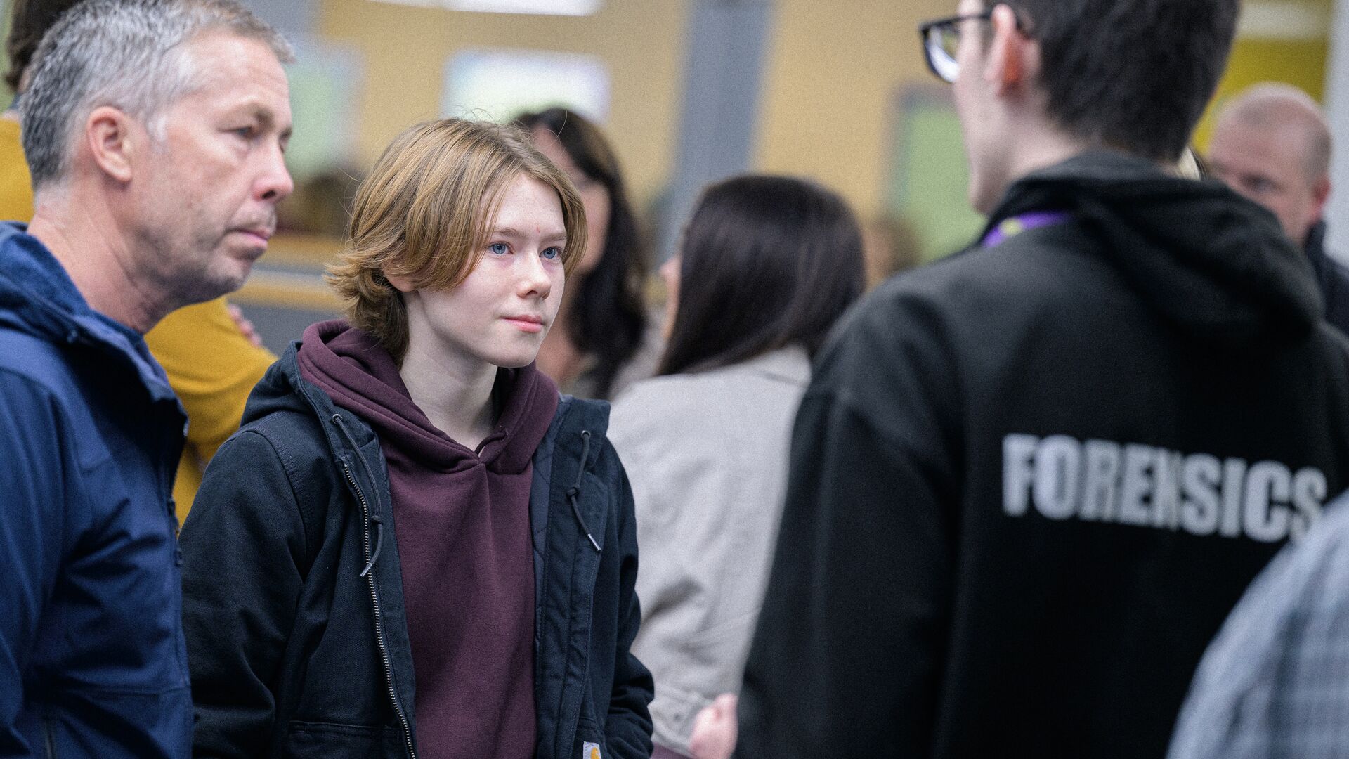 a young adult and supporter talking with a forensics lecturer on a University Open Day