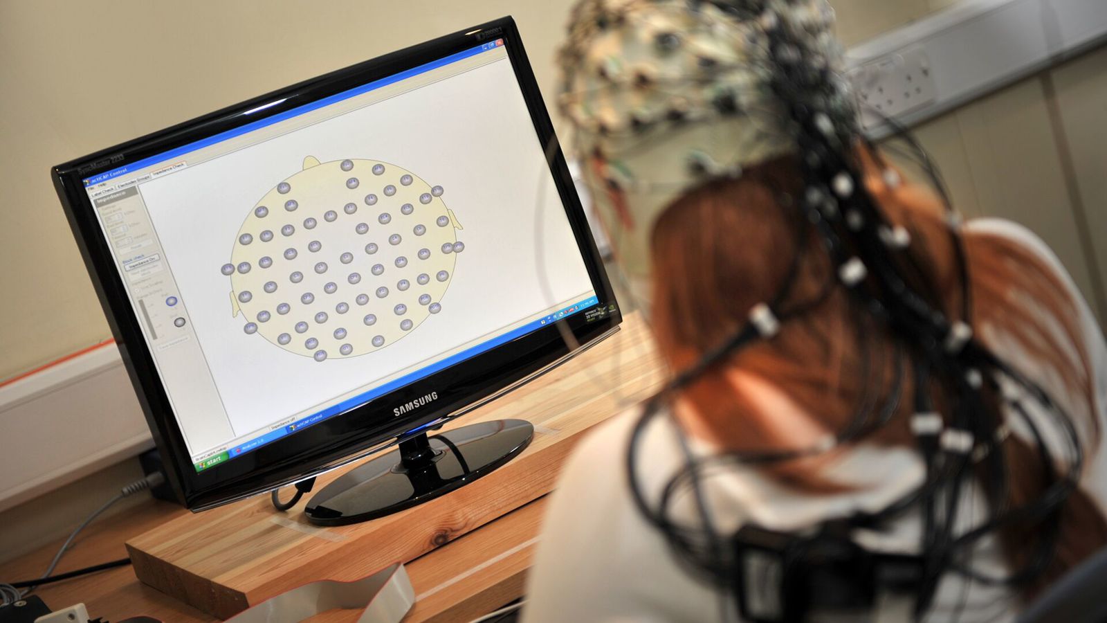 A student doing a psychology experiment with a brain cap on.