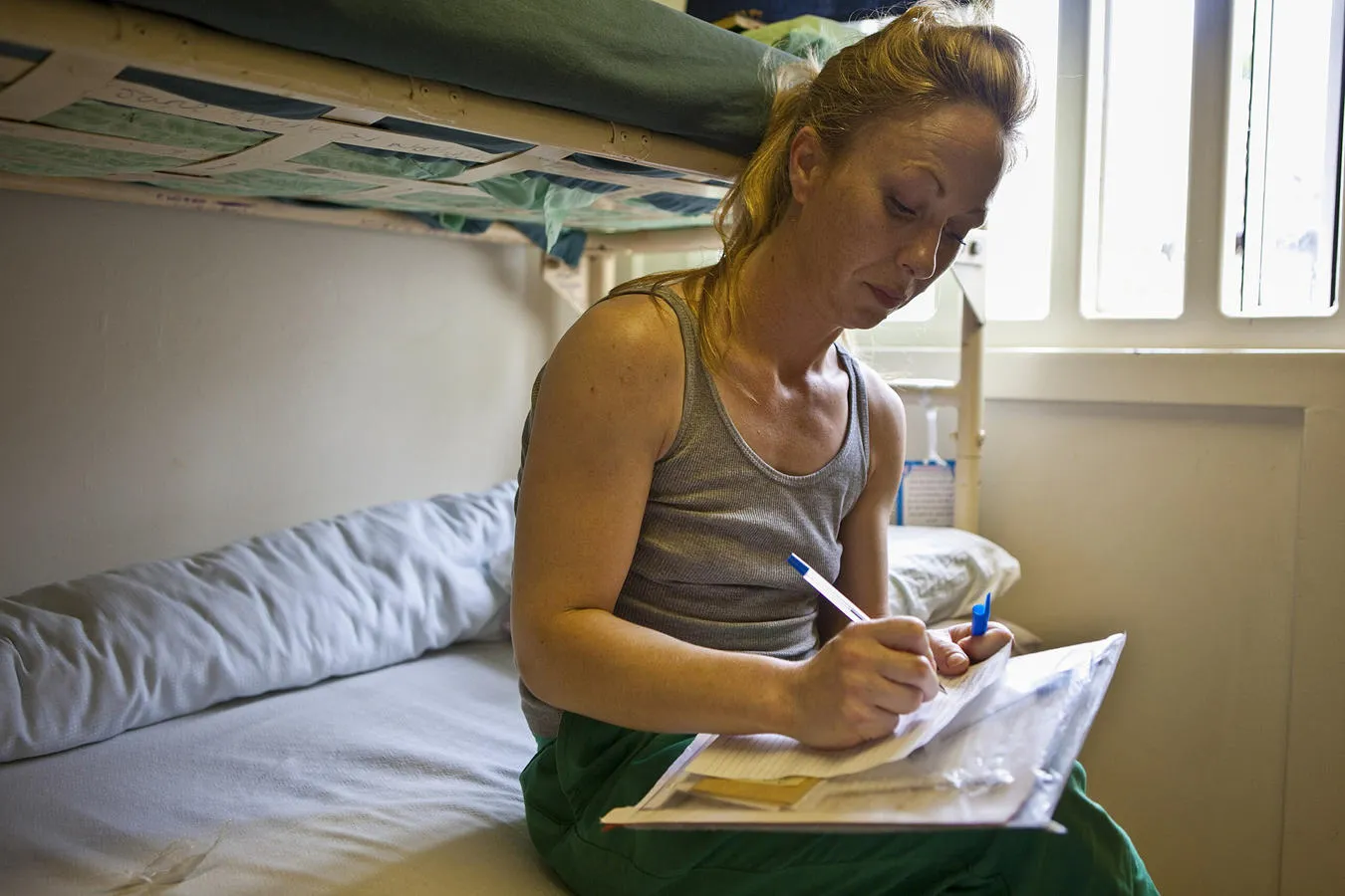 A woman writing in her cell at HMP Styal 