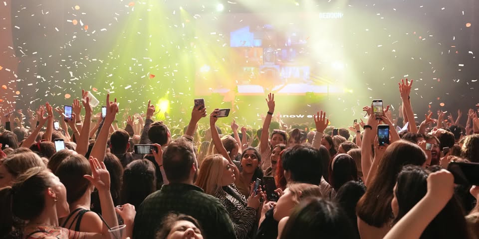 People waving arms at a Swiftogeddon night