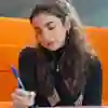 Student sat in a booth writing on paper
