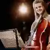 A student with a cello on stage