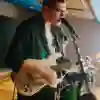 A student playing guitar and singing