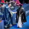 A student shaking hands with the chancellor on the graduation stage.