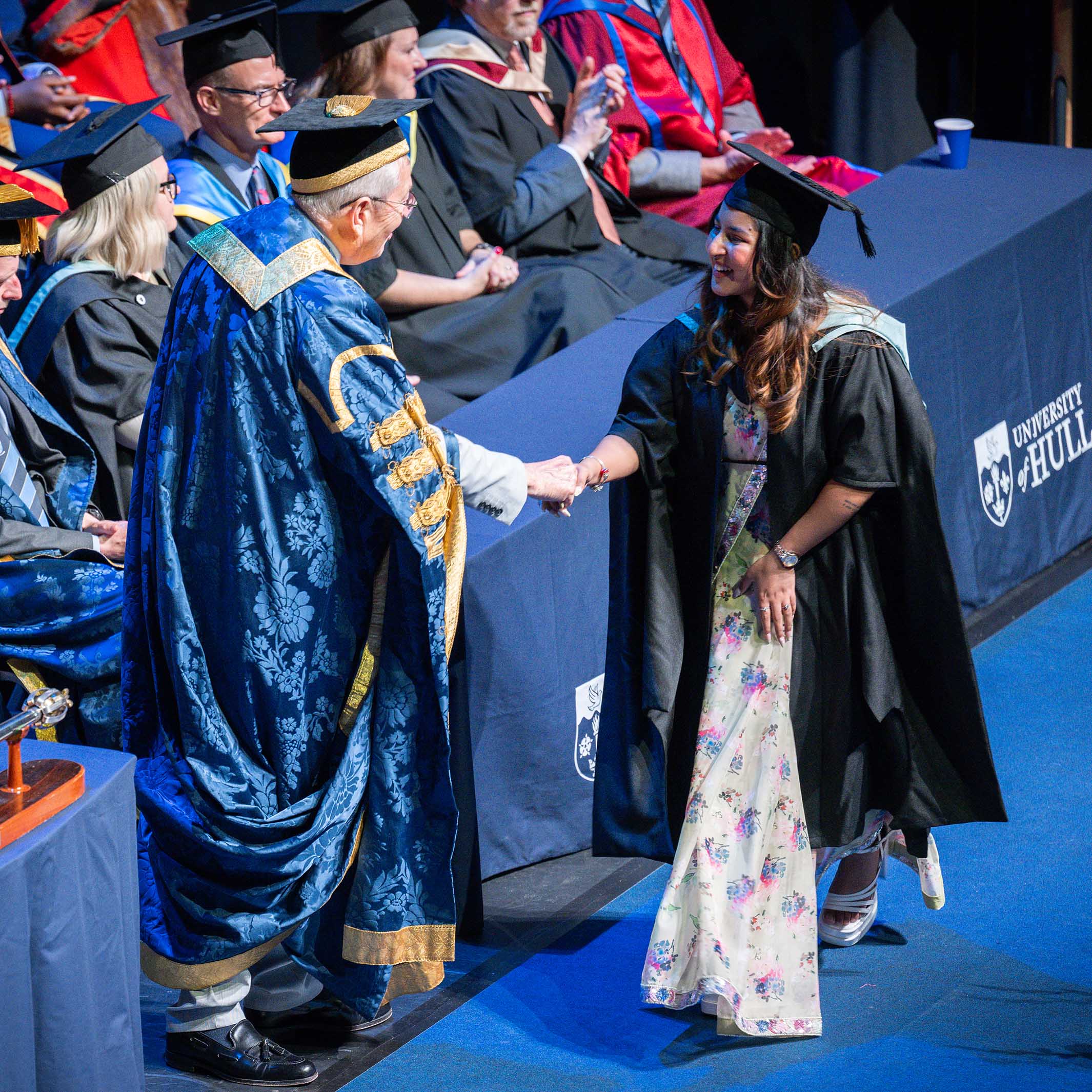 A student shaking hands with the chancellor on the graduation stage.