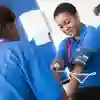 Two health students practise taking each other's blood pressure