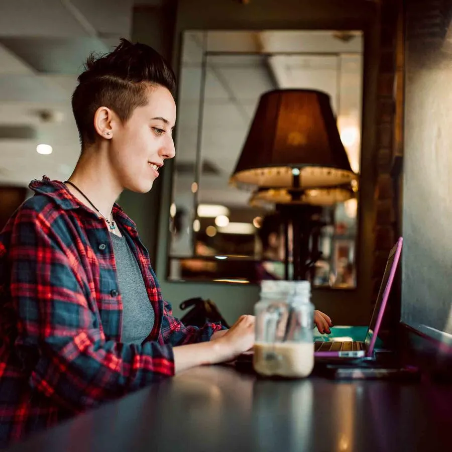 A student uses her laptop in a coffee shop near campus