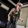 A female student dangles from the ceiling in a harness while wearing a virtual reality headset