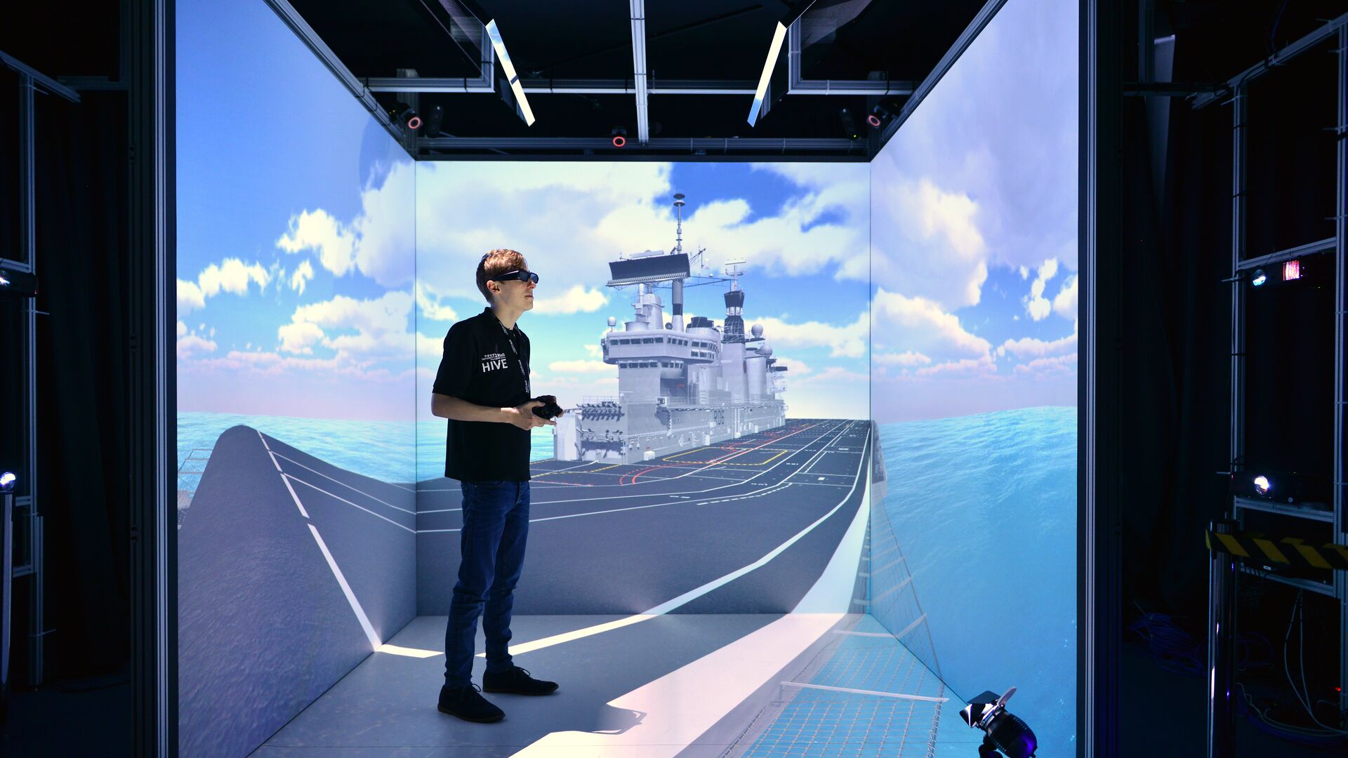A student wearing a VR visor standing in the HIVE cube