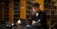 Student sat in the library looking at laptop