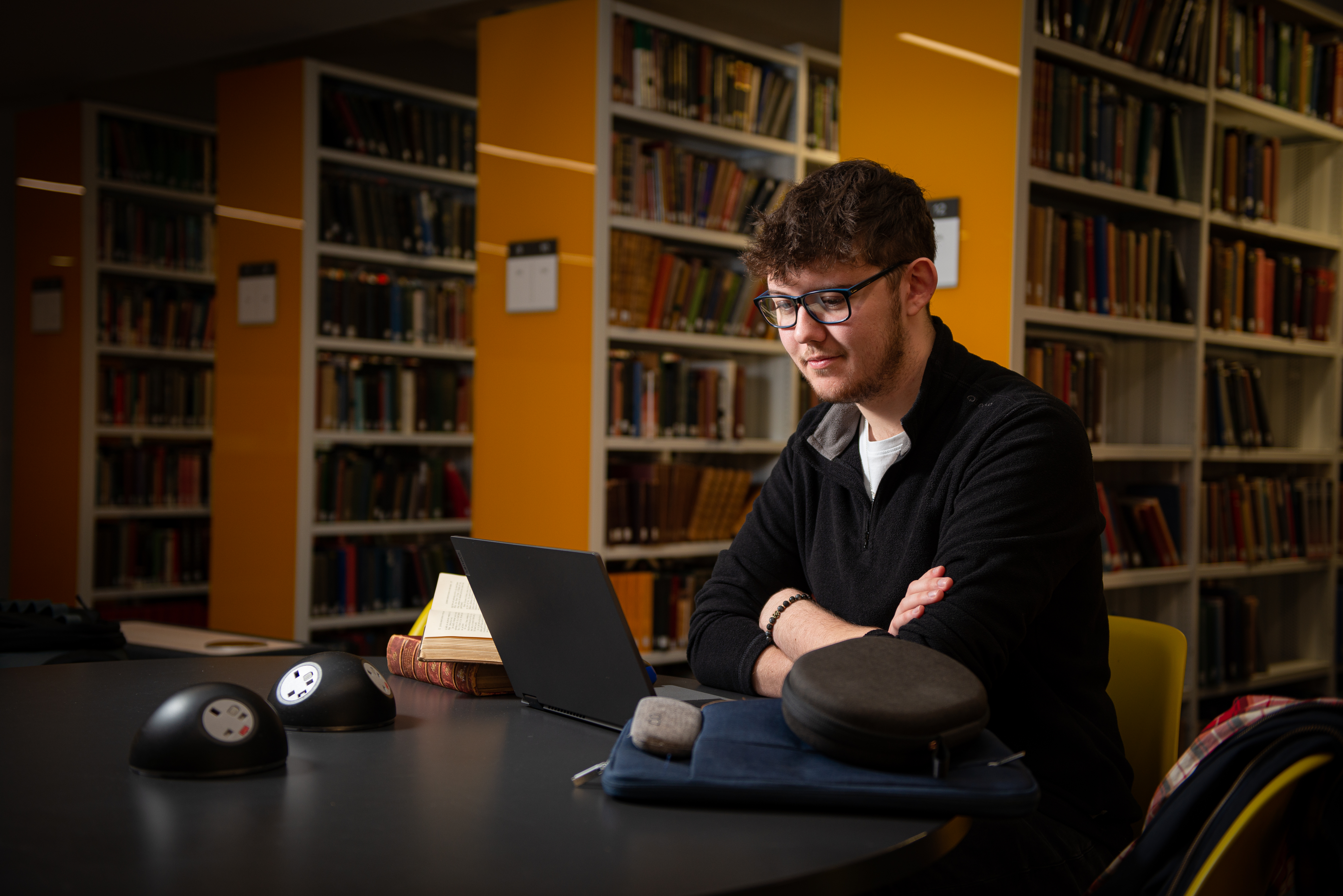 Student sat in the library looking at laptop