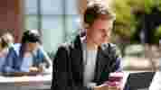 A student on a laptop on a picnic table