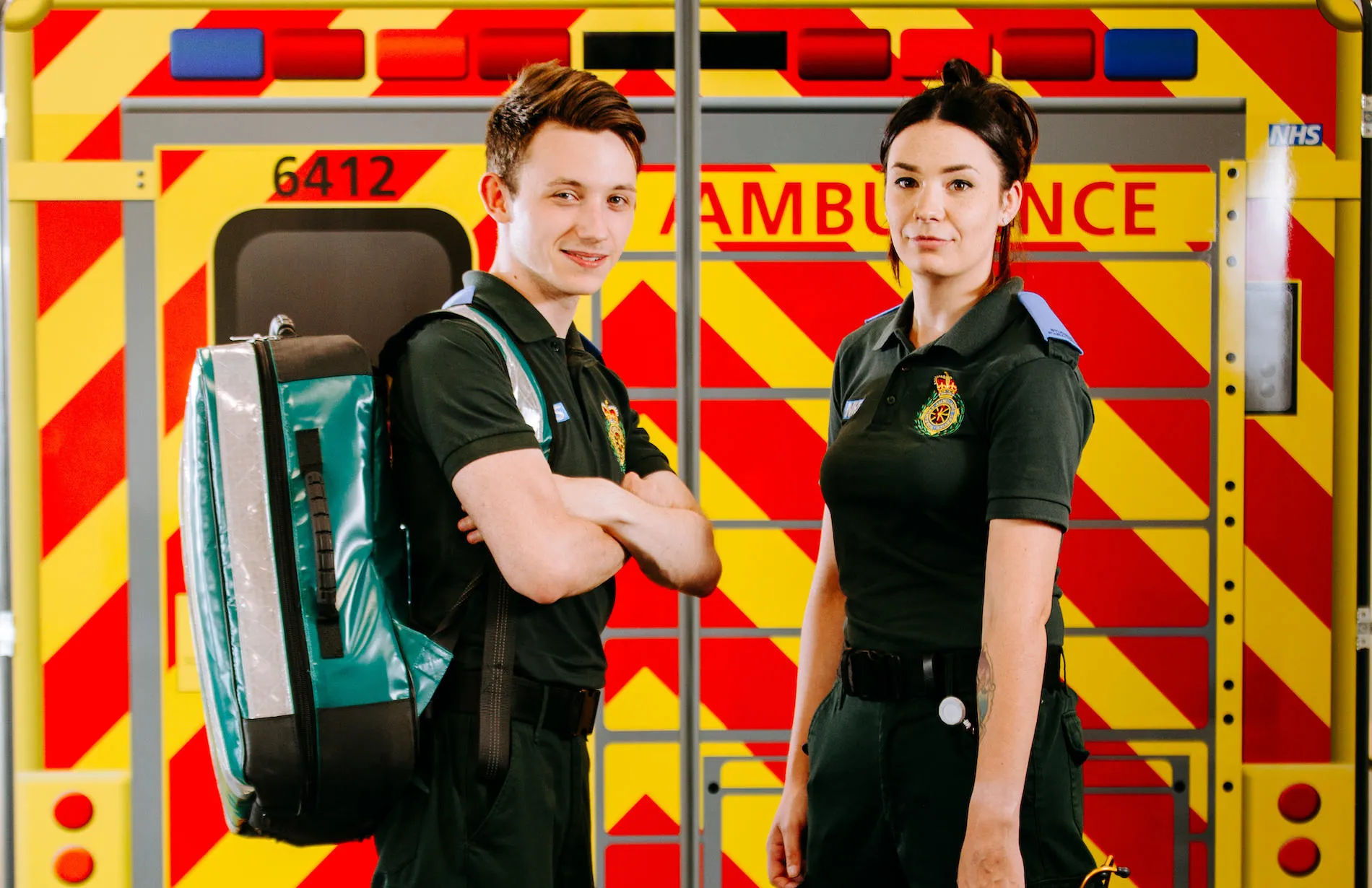 Two student paramedics stood in front of mock ambulance
