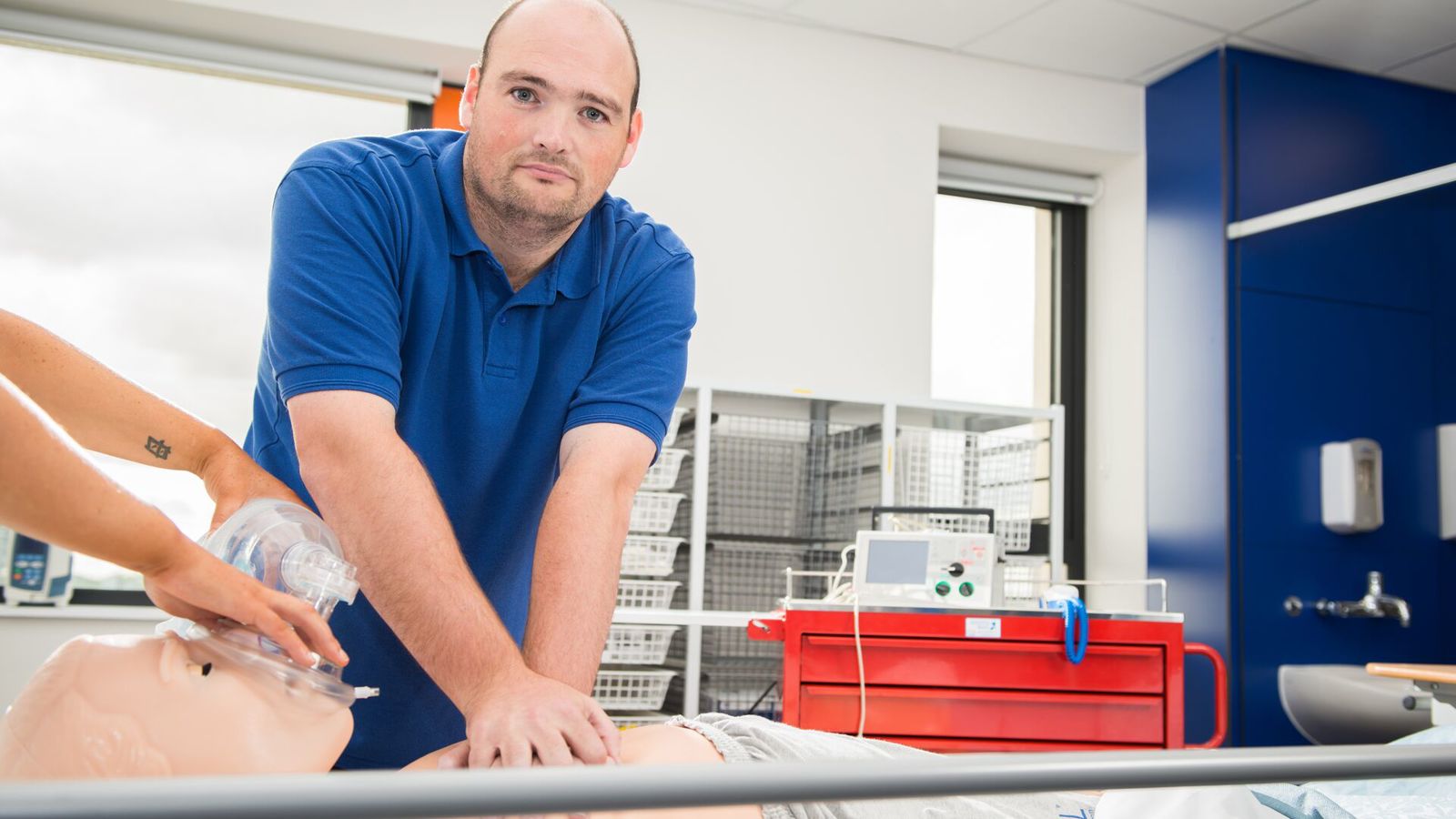 Adult Nursing student David Taylor practises CPR on a mannequin in a mock hospital ward