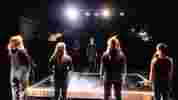 four students stood on stage