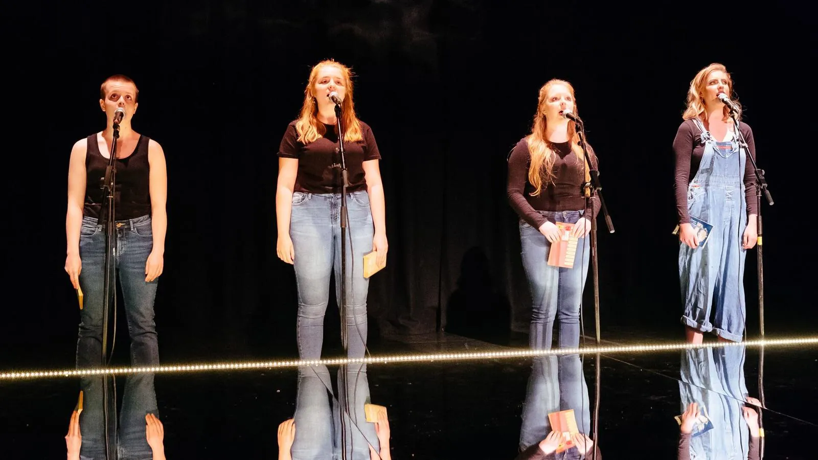 four students stood on stage