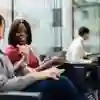 two students on chairs in business lounge chatting