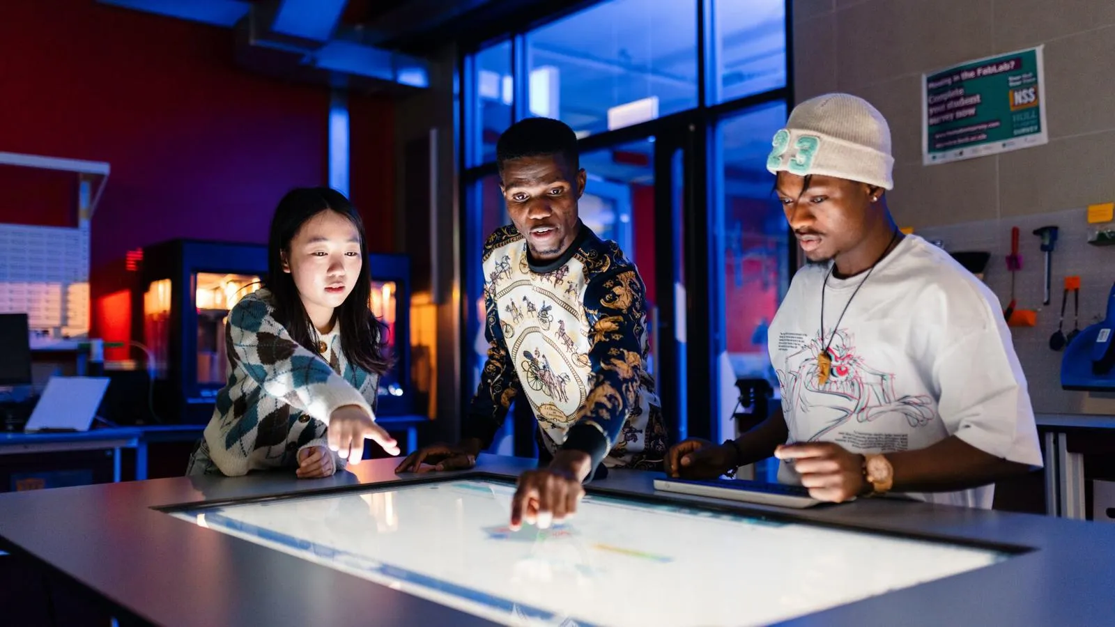 Students using a large touchscreen in the Computer Science Swift Additive Manufacturing Space