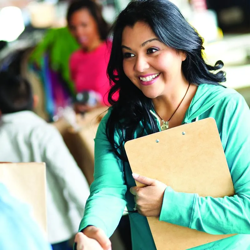 Two students shaking hands with the main focus on a female student
