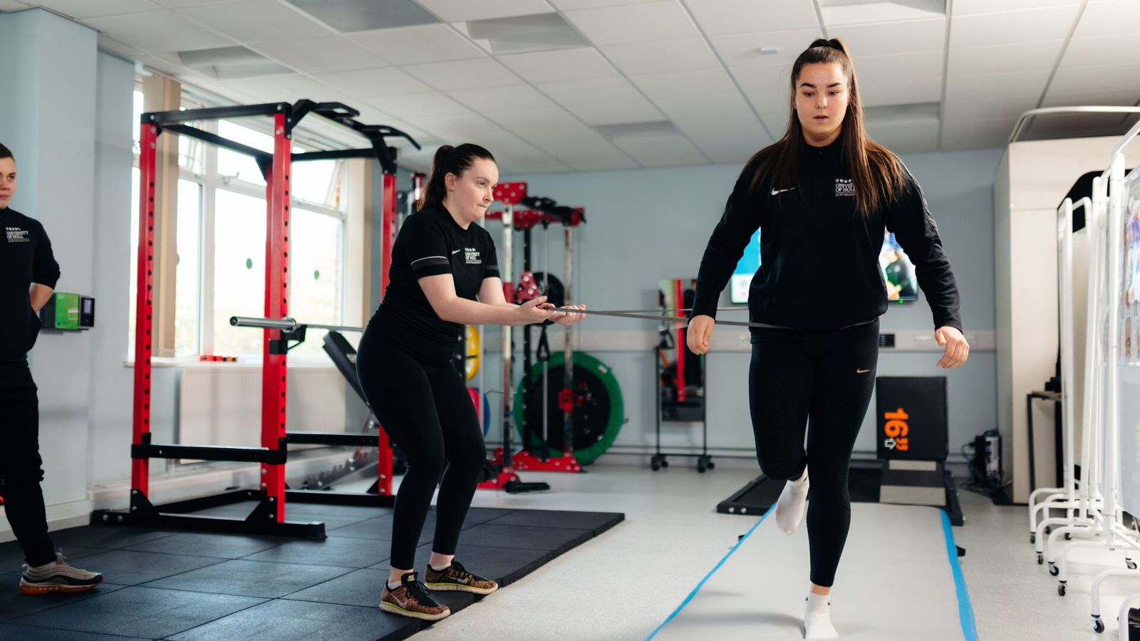 Two students in a rehab suite, one balanced on one leg