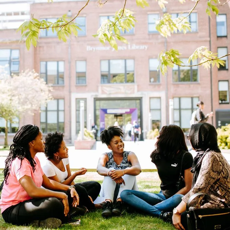 Student Ambassadors Sat Chatting on Grass by Library