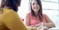 Two social work students smiling while sitting around a table
