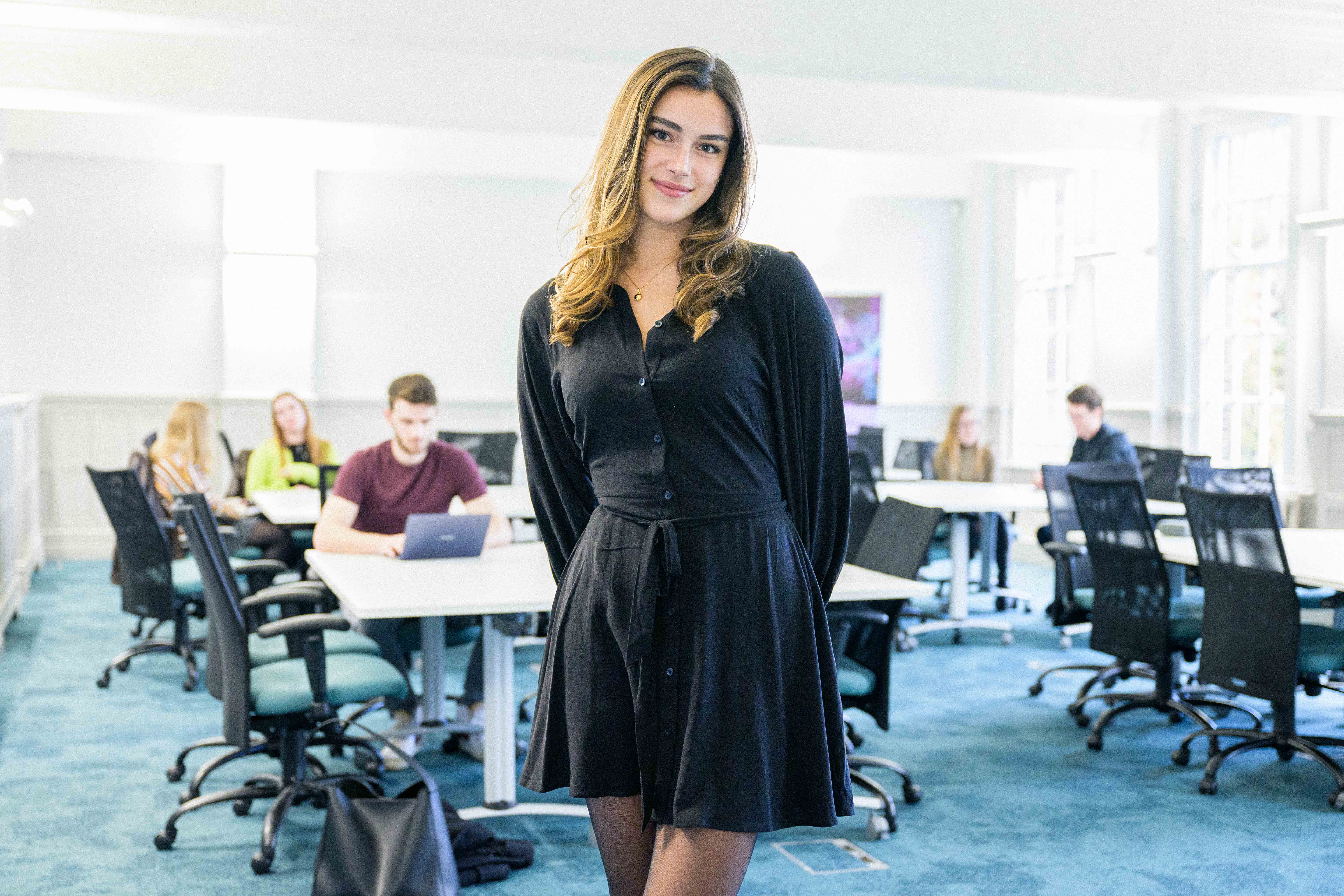 Student stood posing in front of classroom