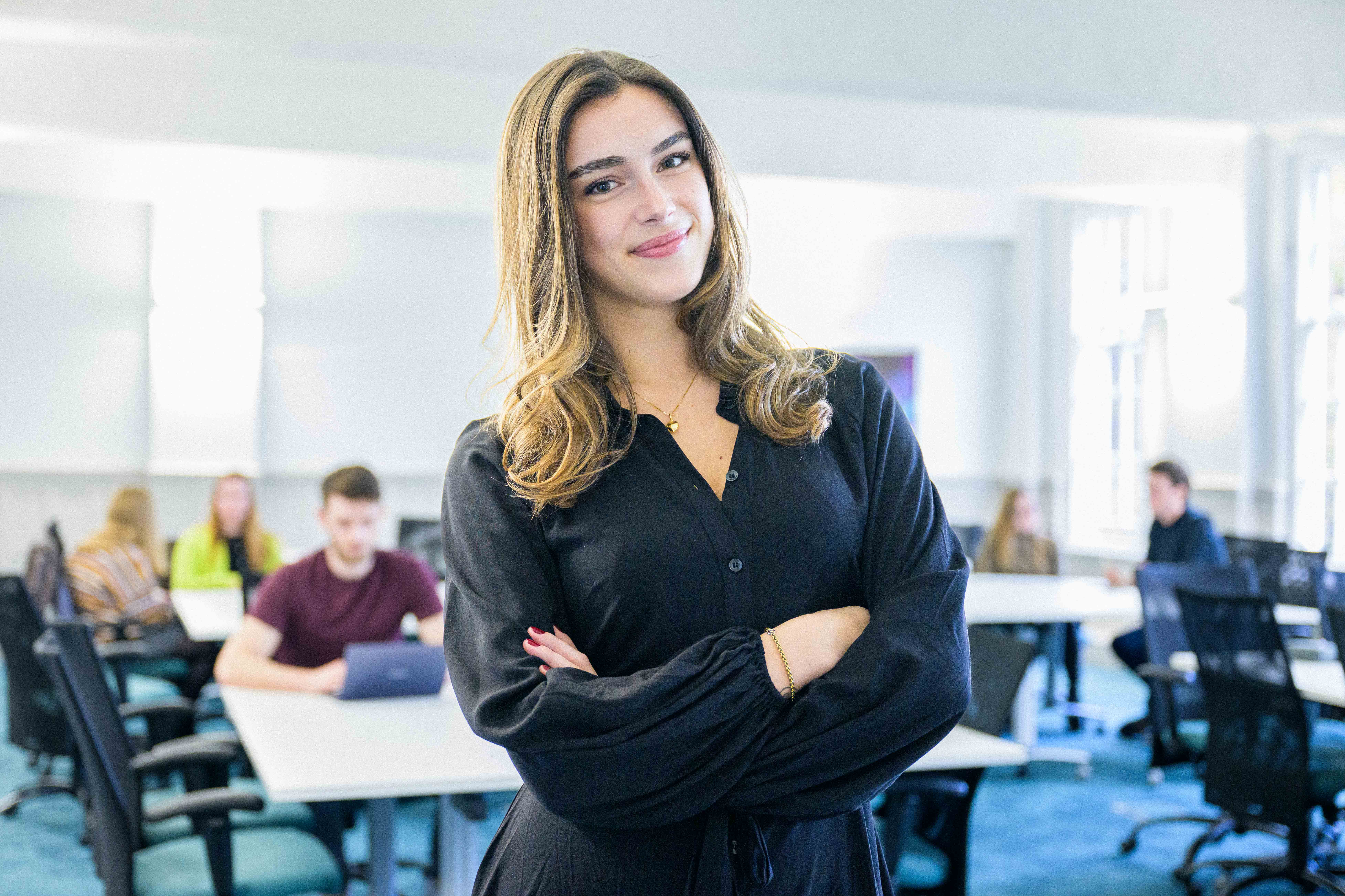 Student stood posing in front of classroom