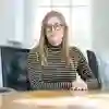 Student sat at desk posing in front of classroom