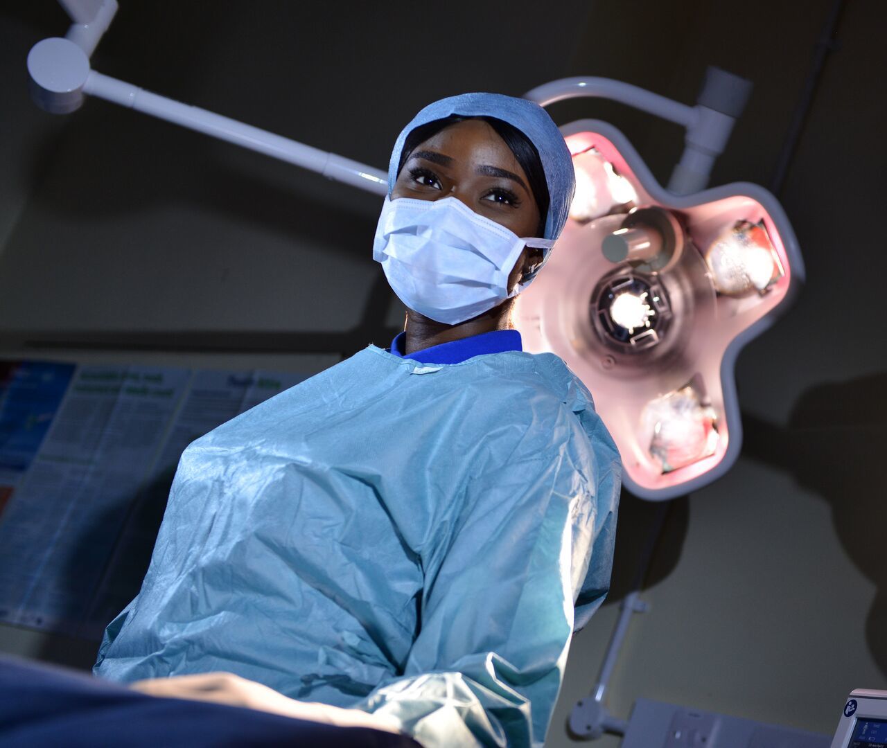 ODP student Olayemi Elizabeth Ajayi stands in scrubs at an operating table under the lights
