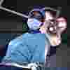 ODP student Olayemi Elizabeth Ajayi stands in scrubs at an operating table under the lights