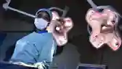 ODP student Olayemi Elizabeth Ajayi stands in scrubs at an operating table under the lights